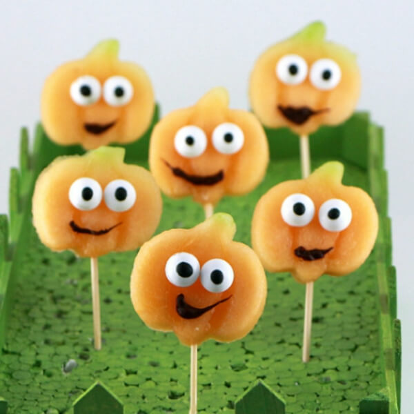 Cute Happy Pumpkin Party Food Made With Slices of Cantaloupe Melon & Candy Eyeballs - Constructing Fall Snacks For Bigger Children