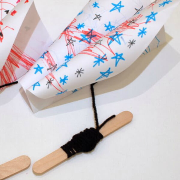 Simple Kite Craft Made With Printed Paper, Yarn, Popsicle Sticks, & Markers - Doing it Yourself Kite Projects For Toddlers