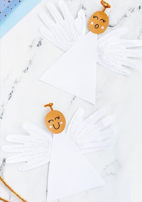 Handprint Angel Craft Activity Using White Cardstock, Pipe Cleaner, & Glitter - Children Crafting Angels During Christmas