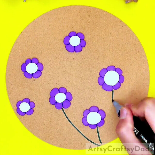 Drawing The Stems Of The Flowers-Designing a bee-themed flower garden out of clay with kids 