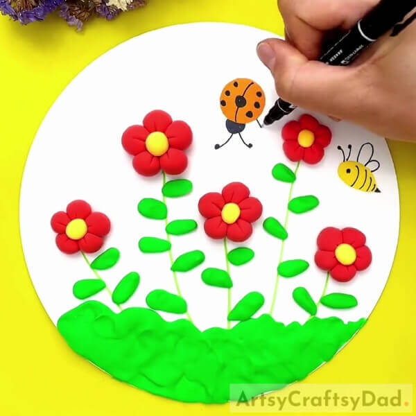 Making A Bug And A Bee- A clay concept of a bee-filled flower garden. 