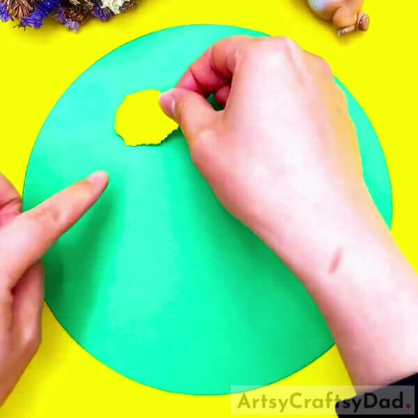 Pasting The Oval Over The Base-An easy paper-tearing flower project for kids.