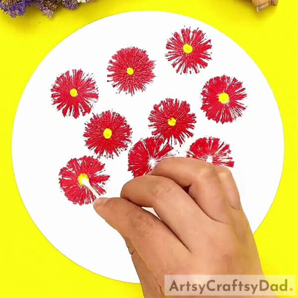 Adding a yellow centre to each flower- Paint red vector flowers with a stamp - a tutorial for kids.