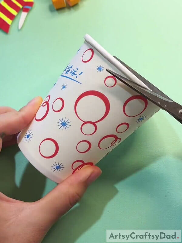 Cutting Out The Edge Of The Paper Cup- Paper Cup Crafting Guide For Children With Curly Hair