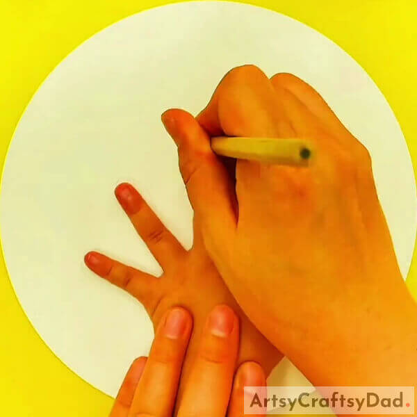 Draw an outline of your hand using a pencil - Step-by-step Guide for Children to Create a Tree Drawing Using Hand Outlines 