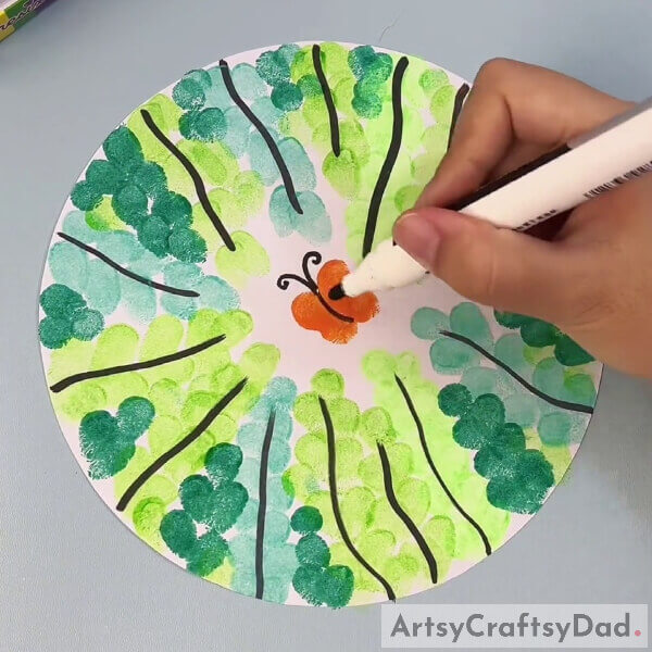 Drawing Antenna For Our Butterfly Using A Black Marker- Learn how to finger stamp a tree with a butterfly art tutorial 