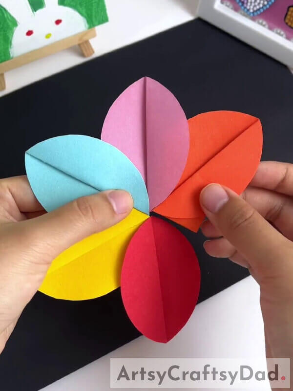 Inserting Petals To Make A Flower - Learn how to construct a paper pinwheel flower craft with kids 
