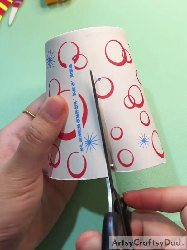 Making A Cut On The Paper Cup- Step-By-Step Guide For Little Ones With Curly Locks To Create A Paper Cup Art Project