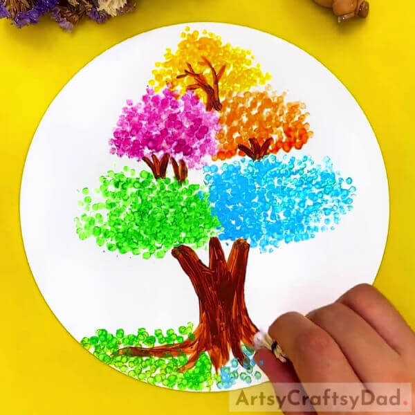 Making Ground Filled With Fallen Leaves- Earbud stamping can create a vivid tree art piece for kids. 