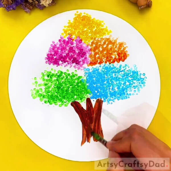 Making The Tree Trunk- Earbuds are great for making artistic tree designs for kids. 