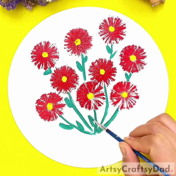 Painting the leaves of the flowers- A tutorial to help kids produce a stamp painting of red vector flowers. 