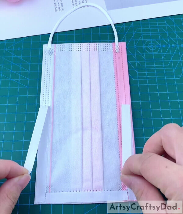 Pasting Double-sided Tape On A Surgical Mask- Discover the steps to creating a pouch for a surgical mask. 