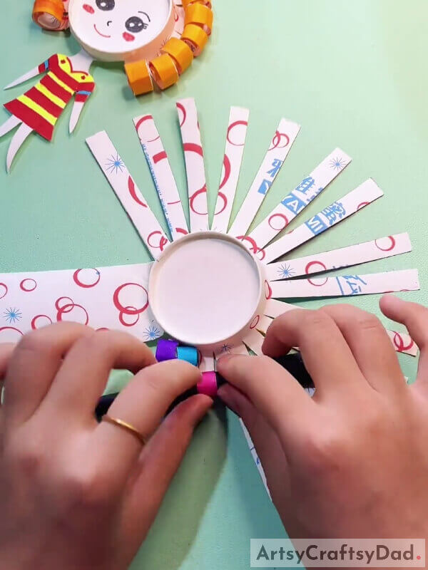 Rolling The Thin Strips- Curly Tressed Children Can Follow This Tutorial To Make A Paper Cup Craft