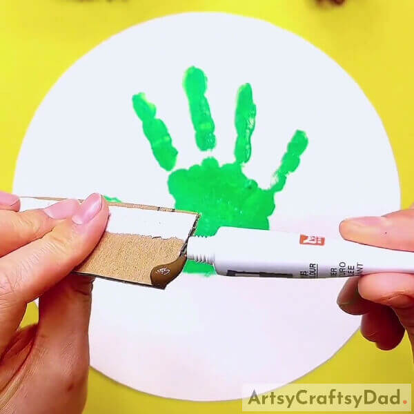 Cutting Cardboard Sheet And Applying Brown Paint On It- A Guide to Crafting a Handprint Cactus Painting for Newcomers