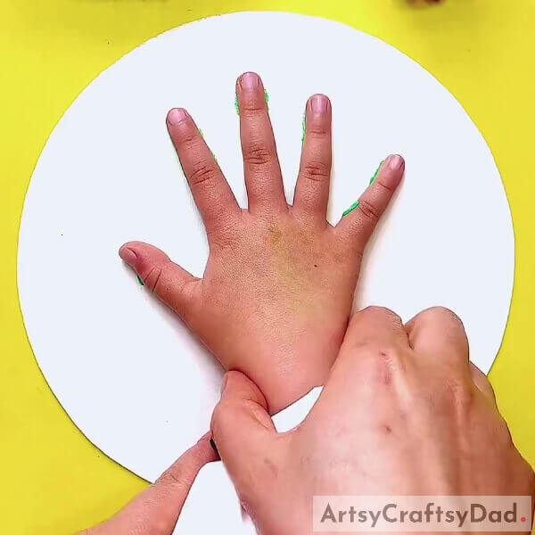 Dipping Hand On Green Color Acrylic Paint-Step-by-Step Guide to Making a Handprint Cactus Artwork for Novices