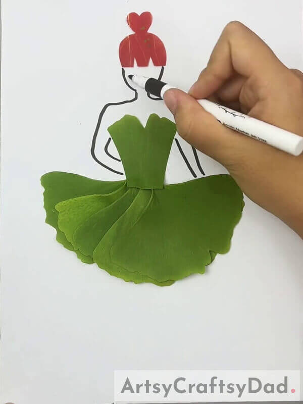 Drawing Girl's Face And Hands Using A Black Marker- Guide For Constructing An Eye-Catching Leaf Dress For Children