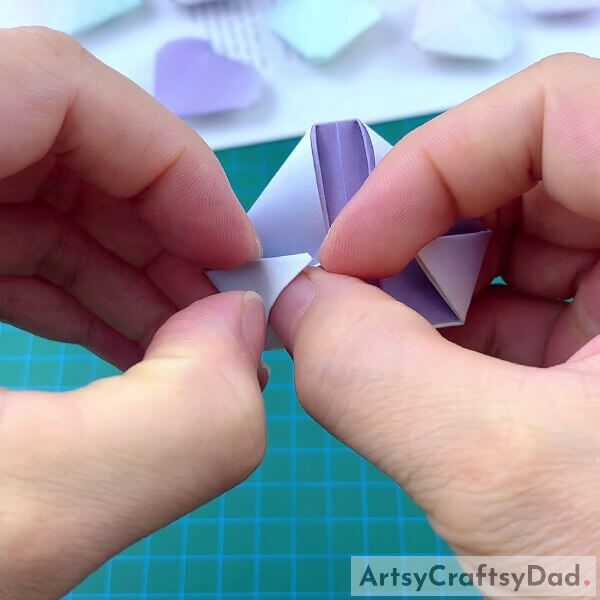 Folding Corners Of Craft Paper- Teaching kids how to make a paper heart origami craft