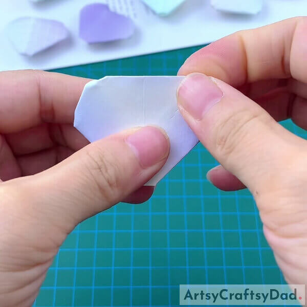 Folding The Edges Of Origami Heart- Guiding children through the process of constructing a paper heart origami