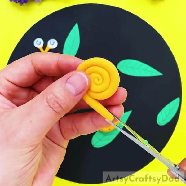 Making A Cut On The End Of The Roll- Colorful Clay Snails On Leaves Craft For Kids