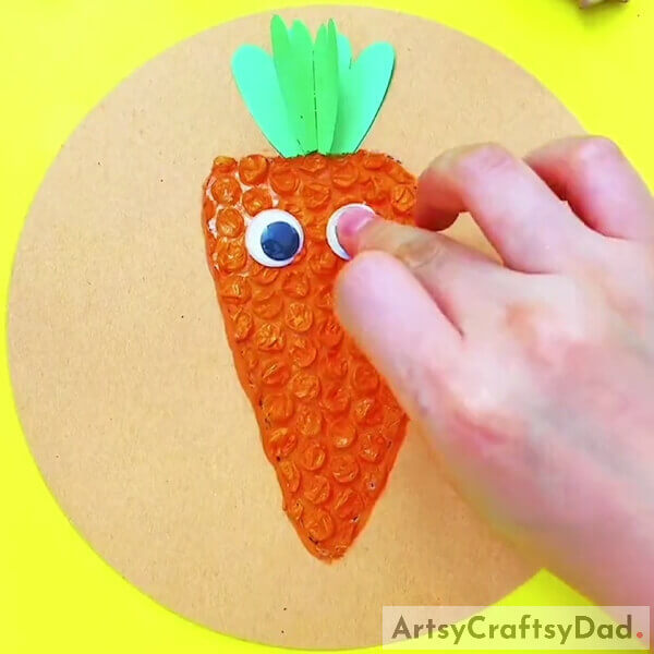 Pasting Googly Eyes- Step-by-Step Tutorial for Making Art with Bubble Wrap and Carrots for Kids