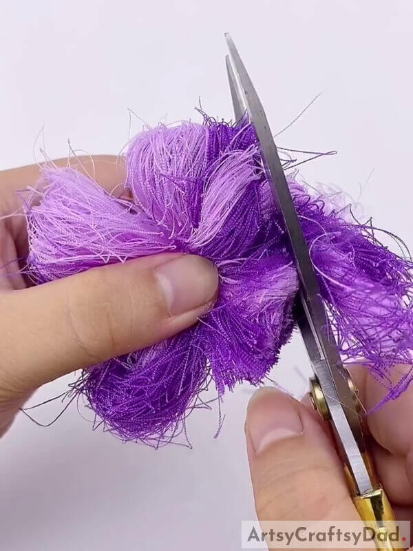 Cut off the edges using a pair of scissors - The Art of Creating Ribbon Pom-Pom Blooms for Little Ones