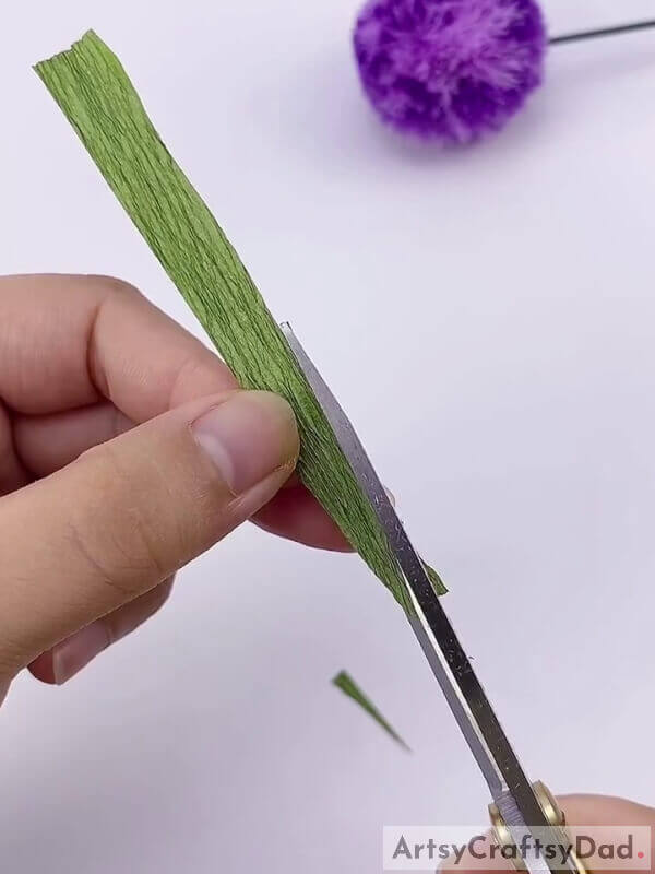 Cut one of the sides of the stripes to make it more pointed - Learn How To Make A Ribbon Pom-Pom Flower With This Kids' Craft Tutorial