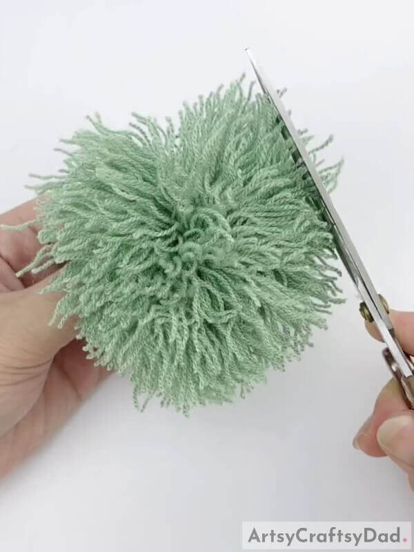 Cut out the extra threads to make it even - Tutorial on Making Pom-Pom Flowers Using Wool Thread