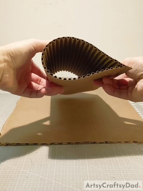 Fold the cardboard but do not make a crease - Making a Special Cardboard Vase for Youngsters