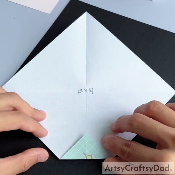 Fold the paper from one of the corners - Steps to construct a paper origami couch for children