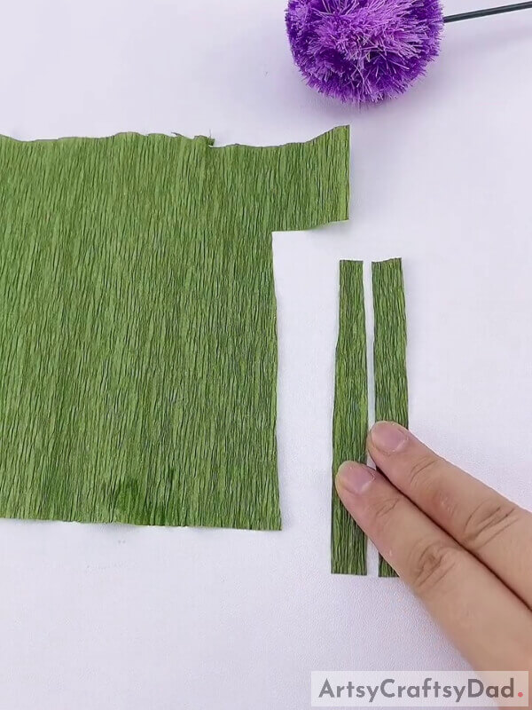 Make leaves out of a green-colored sheet of paper - Crafting Pom-Pom Flowers with Kids Using Ribbons