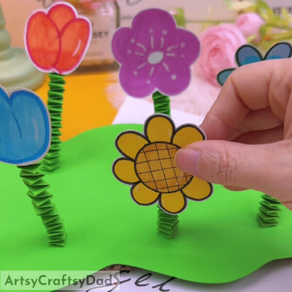 Paste the flowers on the top of the green stems - Learn to make a paper flower garden with kids