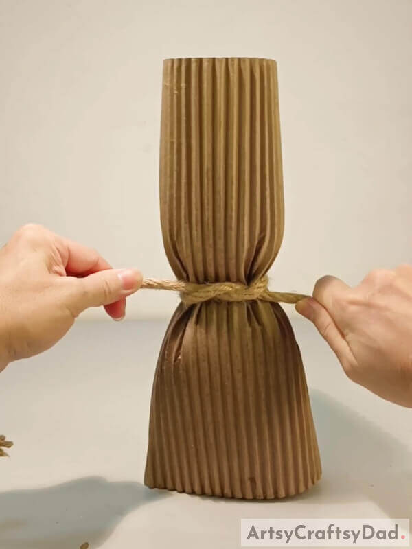 Tie a knot in the rope - Step-by-Step Guide for a Creative Cardboard Vase Craft for Children