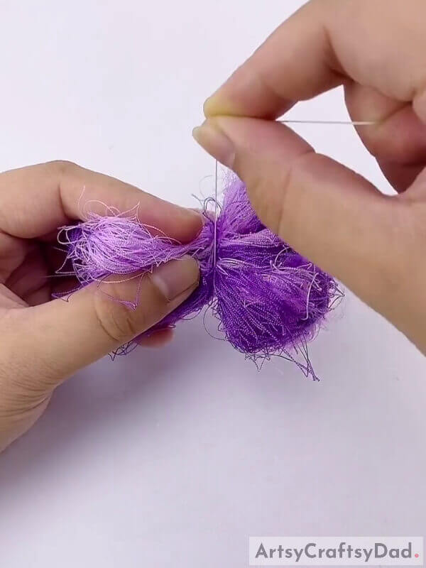 Tie a thread in the middle - A Tutorial for Kids on How to Make Pom-Pom Flowers Out of Ribbons