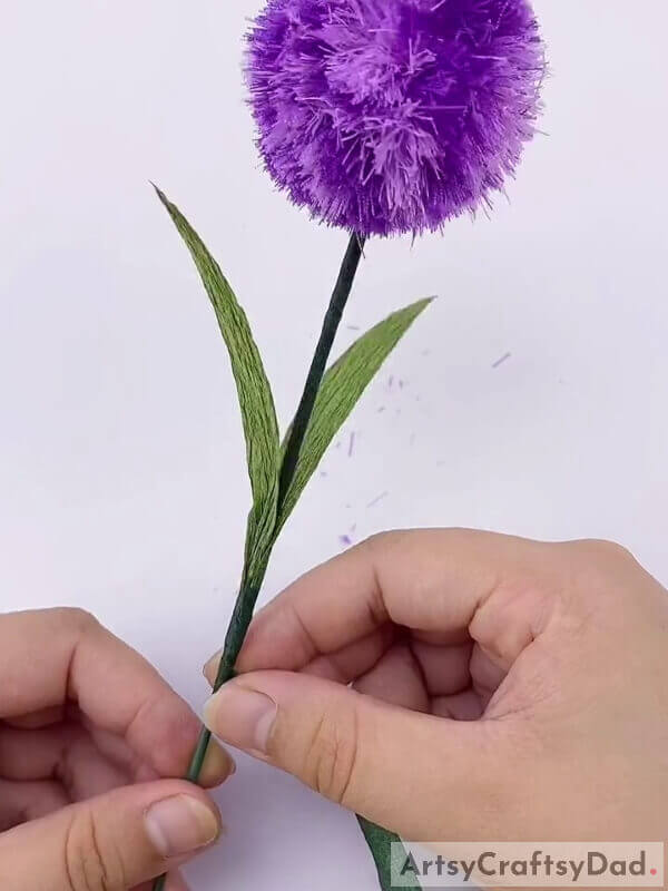 Wrap the strip around the leaves till the end - A Tutorial To Teach Kids To Construct A Ribbon Pom-Pom Flower