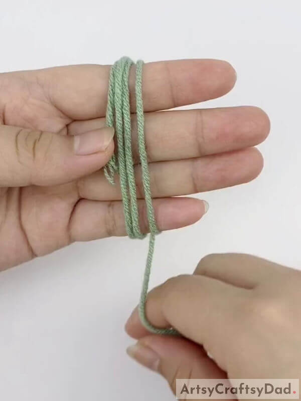 Wrap the wool threads around your fingers - How to Make a Pom-Pom Flower with Wool Thread