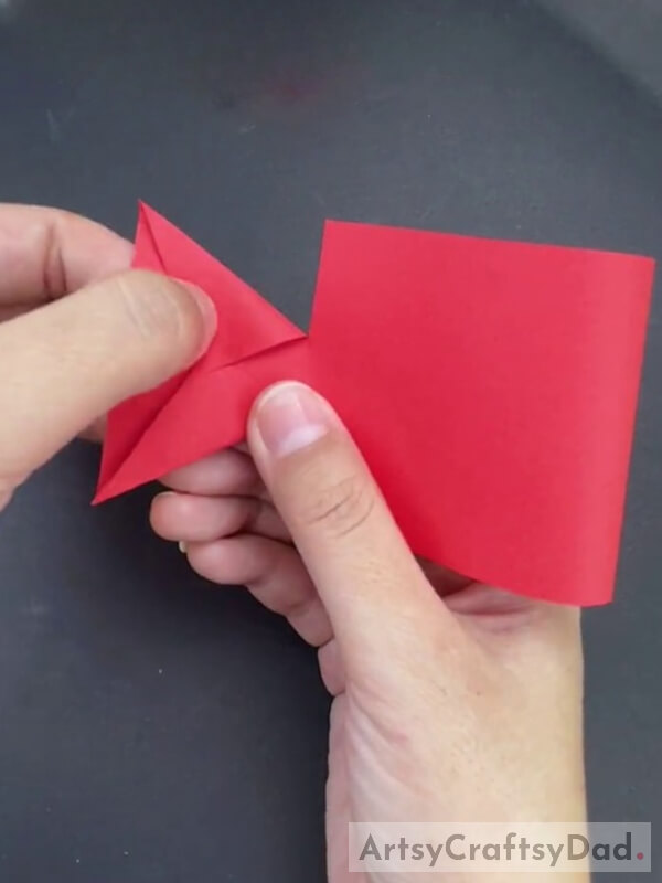 Folding the Three Corners of the Paper Towards the Center of the Paper