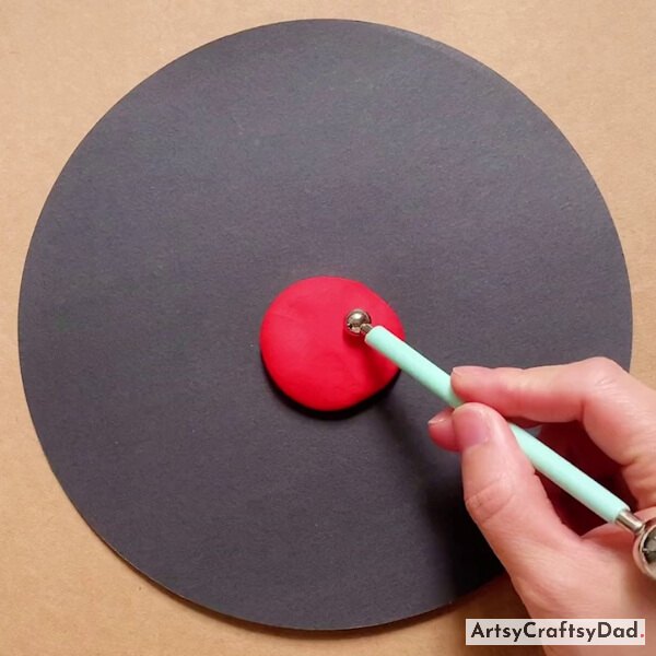 Pressing A Red Clay Circle Using a Craft Iron Roller Tool