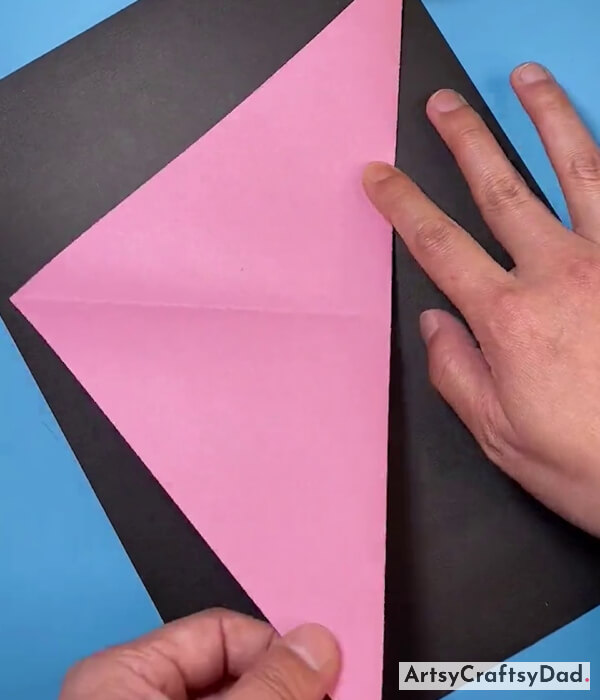Folding The Triangle Shape Pink Paper From The Middle
