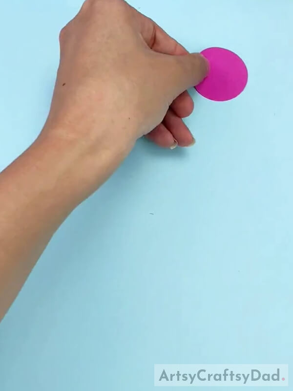 Cutting a Pink Paper Into a Circle Shape