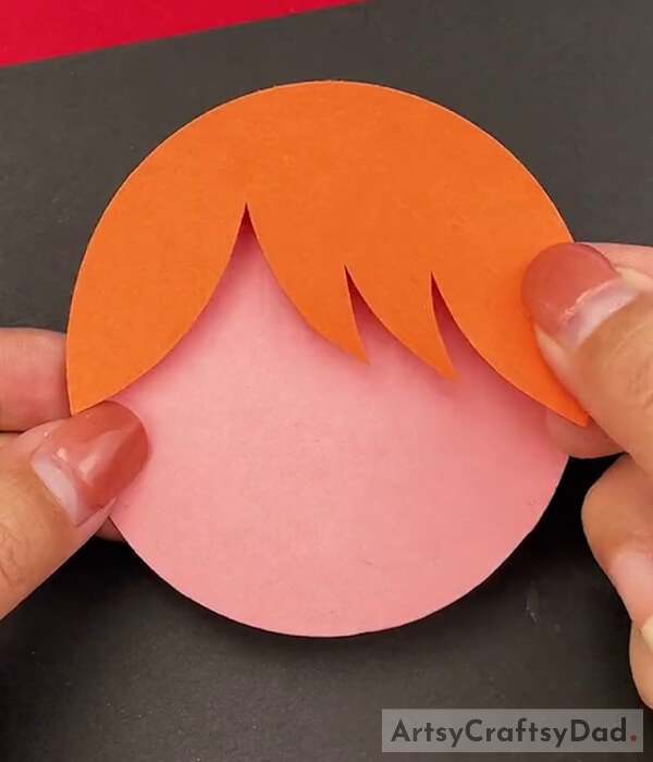 Pasting Hair on a Pink Round Paper