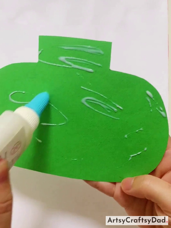 Applying Glue on Green Paper Pot