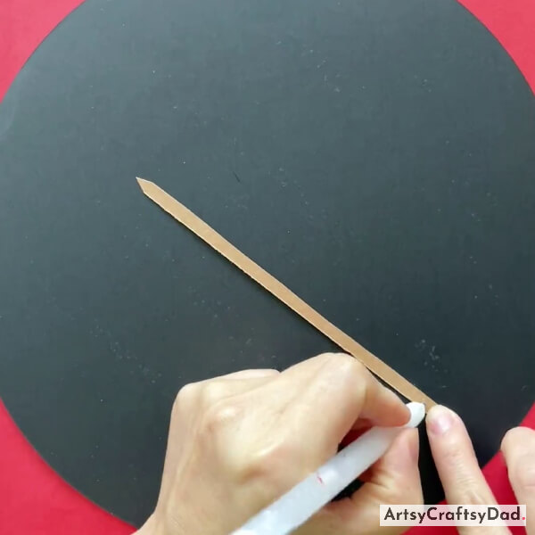Applying Glue On Skin Color Paper Strip