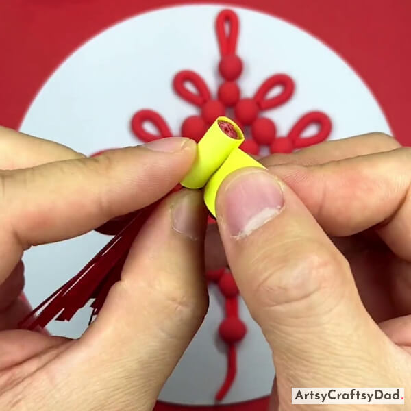 Pasting A Yellow Strip On The One End Of The Tassel