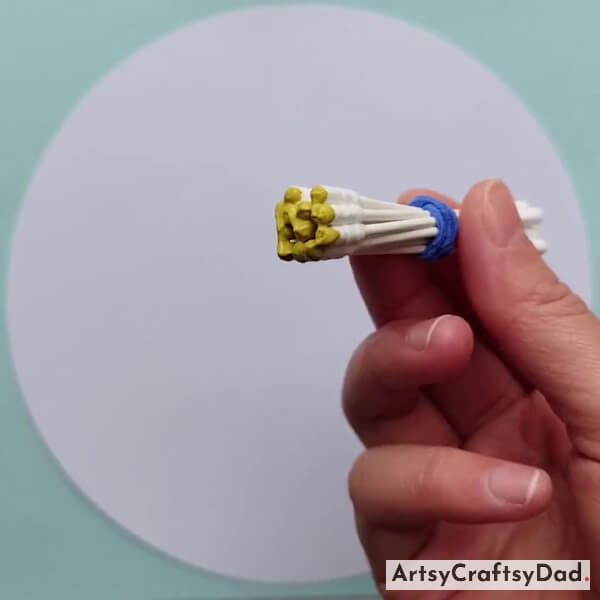 Dipping Earbud Bundle Into Yellow Paint