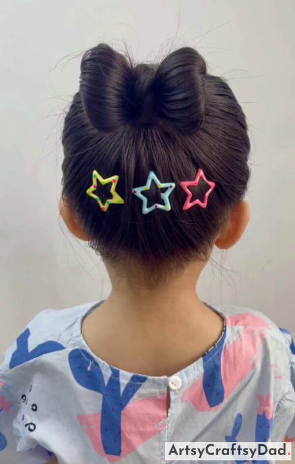 A Bow Bun Hairstyle With Star Clips-Cute hair accessories for children with a braided bun hairstyle.