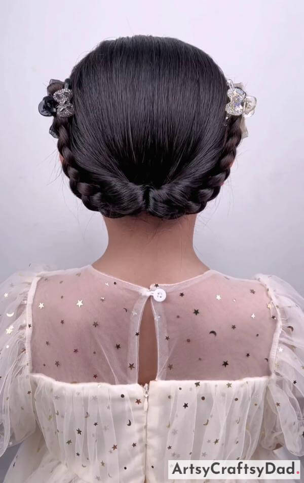 A Half Moon Braided Hairstyle for Kids-Braided bun hairstyle with charming hair clips for children.
