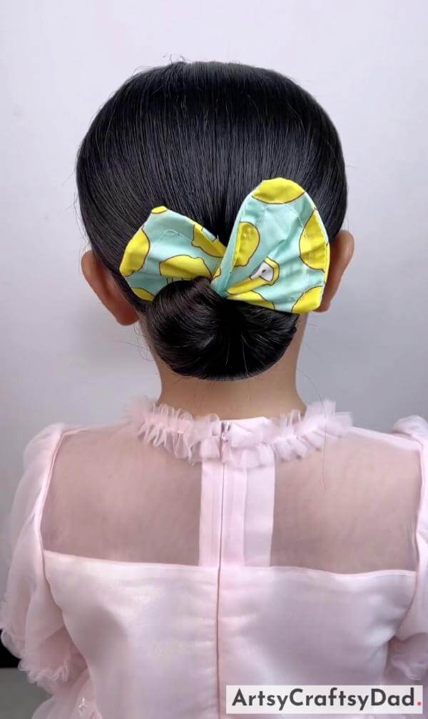 A Simple Bow Bun Hairstyle for Kids- Sweet hairclips and a braided bun hairstyle perfect for kids.