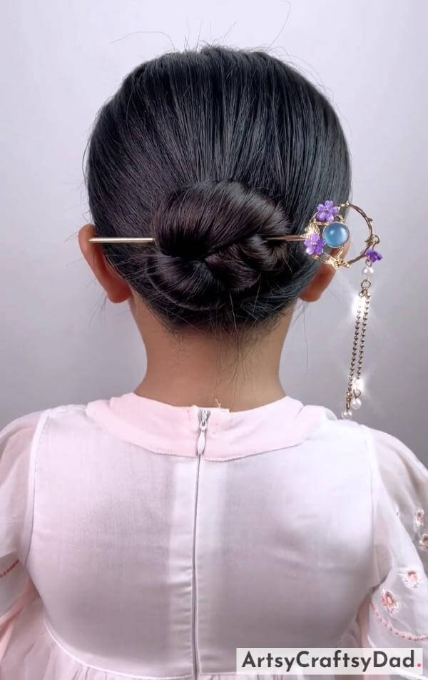 A Twisted Bun Hairstyle for Kids-Lovely hair accessories and a braided bun hairstyle for the little ones.